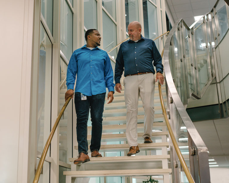 Desmond Jones walking down stairs with coworker